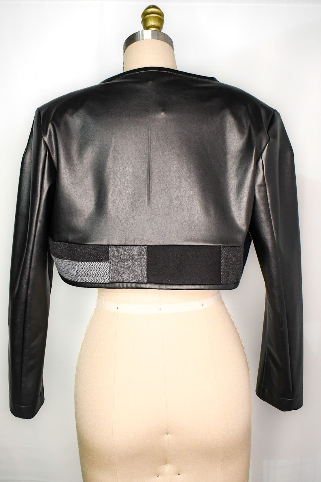 Faux leather cropped bolero with accent hemline in grey, black and grey/