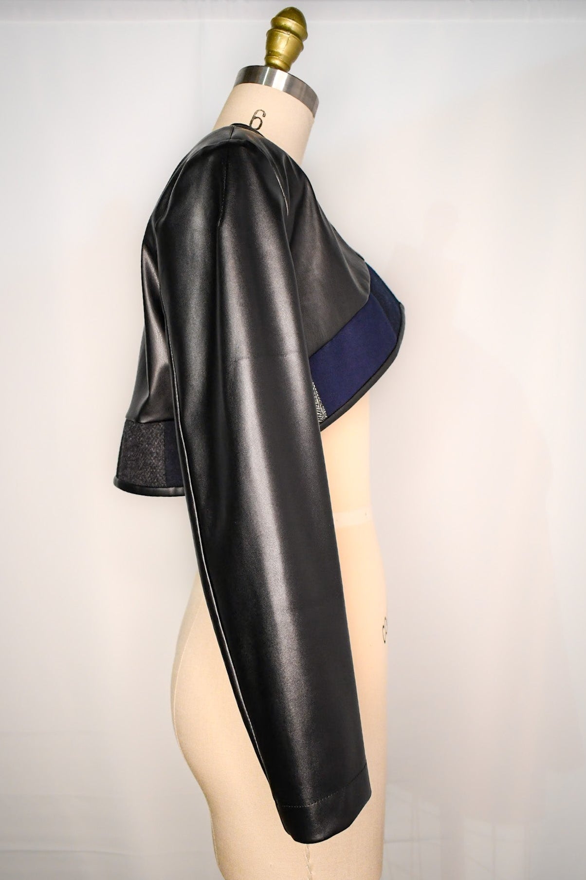 Cropped bolero jackets with blue and grey accent and long sleeves.